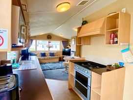 A kitchen with an oven and sofa at 62 Snowdonia View, Hafan y Mor Haven - 4345 Pwllheli