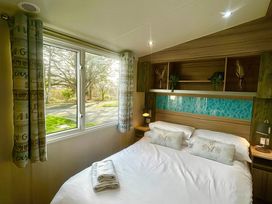 A bedroom with a bed and window at 62 Snowdonia View, Hafan y Mor Haven - 4345 Pwllheli