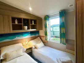 A bedroom with two beds and a window at 62 Snowdonia View, Hafan y Mor Haven - 4345 Pwllheli
