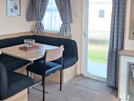 A dining area with a table and seating at Towervans Holiday Park - Holiday Accommodation 5041, Mablethorpe