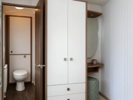 A bathroom with a toilet and storage unit at Hopton Holiday Village - Holiday Accommodation 632, Great Yarmouth