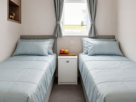 A bedroom with two beds and a bedside table at Hopton Holiday Village - Holiday Accommodation 632 Great Yarmouth
