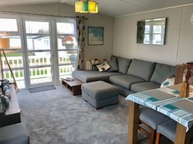 A living room with a sofa and dining table at Hopton Holiday Village - Holiday Accommodation 632, Great Yarmouth