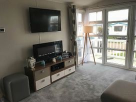 A living room with a television and a fireplace at Hopton Holiday Village - Holiday Accommodation 632 Great Yarmouth