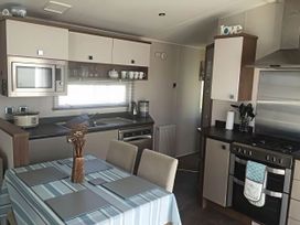 A kitchen with appliances and dining area at Hopton Holiday Village - Holiday Accommodation 632 Great Yarmouth