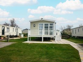 An outdoor view of a mobile home with a deck at Hopton Holiday Village - Holiday Accommodation 632 Great Yarmouth