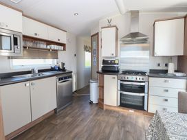 A kitchen with appliances and cabinetry at Hopton Holiday Village - Holiday Accommodation 632 Hopton-On-Sea