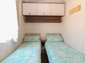 A bedroom with two beds and storage at Hopton Holiday Village - Holiday Accommodation 632 Hopton-On-Sea