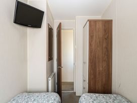 A bedroom with a television and wardrobe at Hopton Holiday Village - Holiday Accommodation 632 Hopton-On-Sea