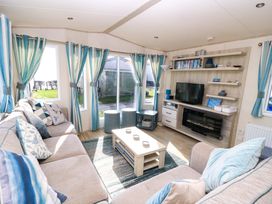 A living room with a sofa and television at Beachcombers in Wareham