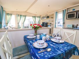A dining area with a table set for meals at Beachcombers in Wareham