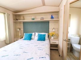 A bedroom with a bed and decorative items at Beachcombers in Wareham