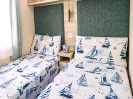 A bedroom with two single beds at Beachcombers in Wareham