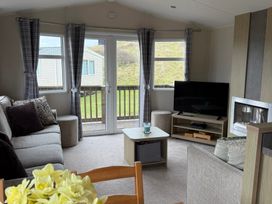 A living room with a sofa and television at Perran Sands - Holiday Accommodation 722 Perranporth