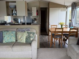 A living room with a sofa and dining area at Perran Sands - Holiday Accommodation 722 Perranporth