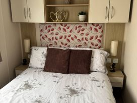 A bedroom with a bed and bedside table at Perran Sands - Holiday Accommodation 722 in Perranporth