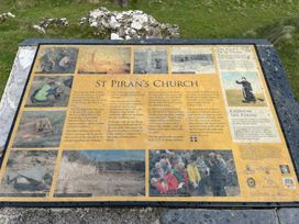 An information board about St Piran's Church in an outdoor area at Perran Sands - Holiday Accommodation 722 Perranporth
