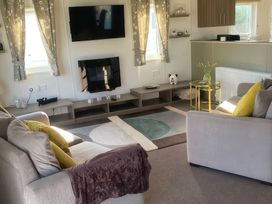 A living room with a television and sofas at White Acres Holiday Park - Holiday Accommodation 8002 Newquay