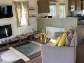 A living room with sofa and television at White Acres Holiday Park - Holiday Accommodation 8002 in Newquay