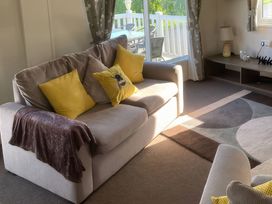 A living room with a sofa and cushions at White Acres Holiday Park - Holiday Accommodation 8002 Newquay