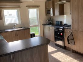A kitchen with a stove and sink at White Acres Holiday Park - Holiday Accommodation 8002 in Newquay