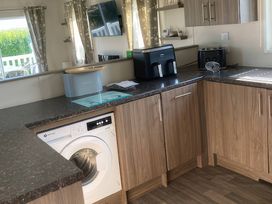 A kitchen with a washing machine and coffee maker at White Acres Holiday Park - Holiday Accommodation 8002 Newquay