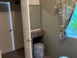 A bathroom with a mirror and vanity at White Acres Holiday Park - Holiday Accommodation 8002 Newquay