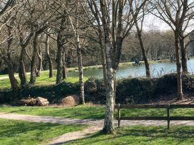 A scenic view with a pond and trees at White Acres Holiday Park - Holiday Accommodation 8002, Newquay