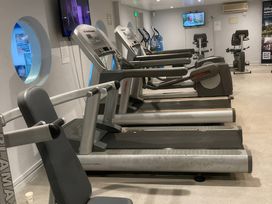 A gym with various exercise machines and a television at White Acres Holiday Park - Holiday Accommodation 8002 Newquay