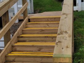 A set of wooden stairs with yellow markings at Praa Sands Holiday Park - Holiday Accommodation 8186, Praa Sands