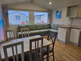 A living room with a sofa and dining table at Golden Sands - Holiday Accommodation 8309 Mablethorpe