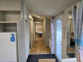 A hallway with a refrigerator and doors at Golden Sands - Holiday Accommodation 8309 Mablethorpe