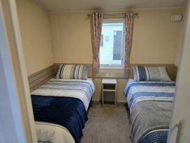 A bedroom with two single beds and a window at Golden Sands - Holiday Accommodation 8309 Mablethorpe