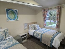 A bedroom with two beds and a window at Golden Sands - Holiday Accommodation 8309 Mablethorpe