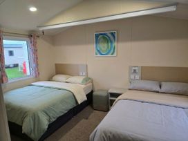 A bedroom with two beds and a window at Golden Sands - Holiday Accommodation 8309 Mablethorpe