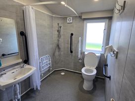 A bathroom with a shower, toilet, and sink at Golden Sands - Holiday Accommodation 8309 Mablethorpe