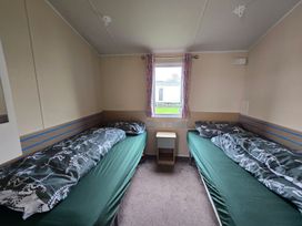 A bedroom with two single beds and a window at Golden Sands - Holiday Accommodation 8309 Mablethorpe