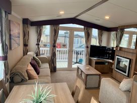 A living room with a sofa and television at Seashore Holiday Park - Holiday Accommodation 848 in Great Yarmouth
