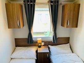 A bedroom with two beds and a window at Seashore Holiday Park - Holiday Accommodation 848, Great Yarmouth