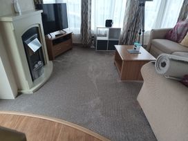 A living room with a fireplace and television at Aberystwyth Holiday Village - Holiday Accommodation 9213, Aberystwyth