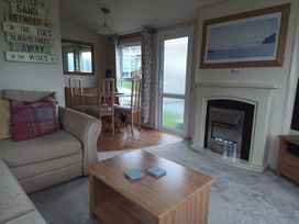 A living room with a sofa and dining table at Aberystwyth Holiday Village - Holiday Accommodation 9213 Aberystwyth