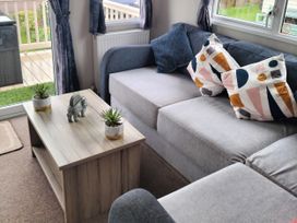 A living room with a sofa and coffee table at Beverley Bay Holiday Park - Holiday Accommodation 9506, Paignton