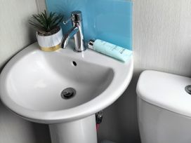 A sink with a plant and bottle next to a toilet at Beverley Bay Holiday Park - Holiday Accommodation 9506 Paignton