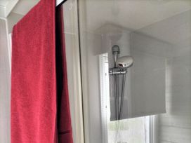 A shower with a towel hanging in the bathroom at Beverley Bay Holiday Park - Holiday Accommodation 9506, Paignton