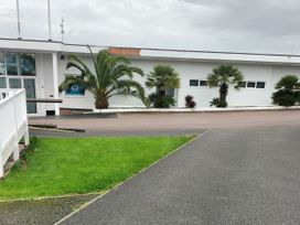 A building with palm trees and a walkway at Beverley Bay Holiday Park - Holiday Accommodation 9506, Paignton