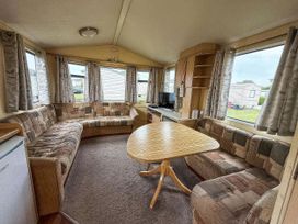 A living room with a sofa and table at Green Farm Caravan Park - Holiday Accommodation 9807 Scratby, Great Yarmouth
