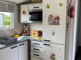 A kitchen with refrigerator and sink at Primrose Valley Holiday Park - Holiday Accommodation 9833 in Filey