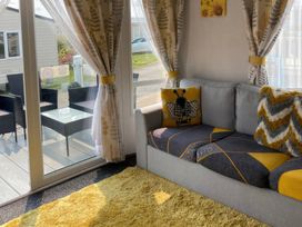 A living room with a sofa and glass table at Primrose Valley Holiday Park - Holiday Accommodation 9833, Filey
