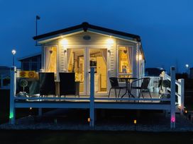 A house with a deck and chairs at Primrose Valley Holiday Park - Holiday Accommodation 9833, Filey