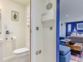 A bathroom with a toilet and mirror at Lakeside Studio in Portreath